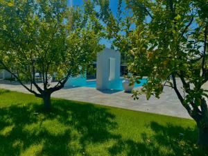 two trees in a yard with a building at Tonnoconte Relais & Restaurant in Andria