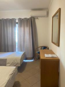 a room with two beds and a desk and a mirror at Castelos da Rocha in Portimão