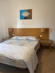 a bedroom with a bed with a wooden headboard at Castelos da Rocha in Portimão