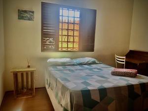 um quarto com uma cama e uma janela em Quarto aconchegante lago igapó em Londrina