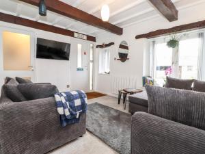uma sala de estar com dois sofás e uma televisão em The Coach House em Carnforth