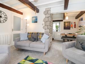 uma sala de estar com dois sofás e uma parede de pedra em Corner Cottage em Carnforth