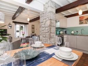 a kitchen and living room with a table and chairs at Corner Cottage in Carnforth
