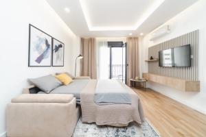 a bedroom with a bed and a couch and a tv at Salus Hill Condo with private Garage in Budva