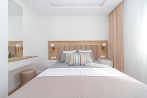 a white bedroom with a large white bed with pillows at Salus Hill Condo with private Garage in Budva