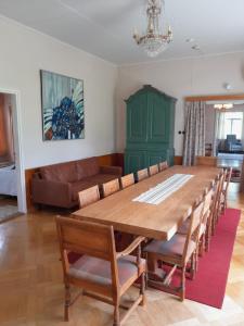a dining room with a large wooden table and chairs at Källgård in Lohja