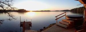 un molo su un lago con il tramonto sull'acqua di Källgård a Lohja