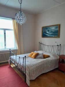 a bedroom with a bed and a chandelier at Källgård in Lohja