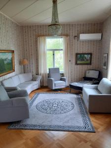 a living room with couches and a rug at Källgård in Lohja
