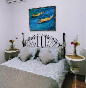 una camera con un letto e una foto appesa al muro di Villa Lola 14 a Chiclana de la Frontera