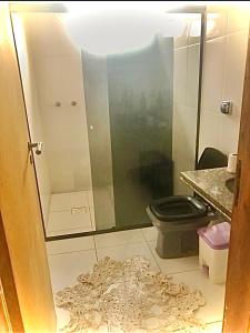 uma casa de banho com um WC e uma cabina de duche em vidro. em Quarto aconchegante lago igapó em Londrina