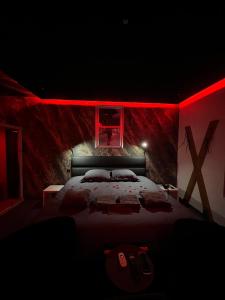 a bedroom with a large bed with red lighting at spa de la quarterelle LOVE ROOM 88 VOSGES in Remiremont