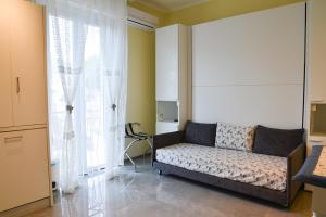 salon z kanapą i oknem w obiekcie la maisonnette di anna w mieście Arma di Taggia