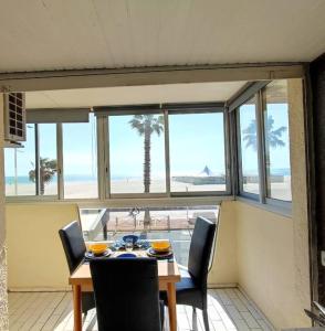 comedor con mesa y sillas y vistas a la playa en Magnifique Vue Mer avec une chambre - Nouria 55 -, en Canet-en-Roussillon