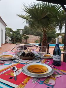 un tavolo con piatti e una bottiglia di vino di Villa Lola 14 a Chiclana de la Frontera