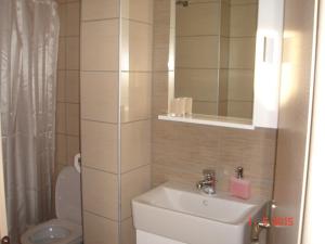 a bathroom with a sink and a toilet and a mirror at Spyridonou House in Parga +104 photos