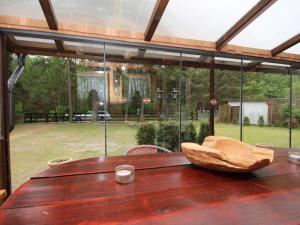 a wooden table in front of a large window at Bungalow, Wernsdorf in Wernsdorf