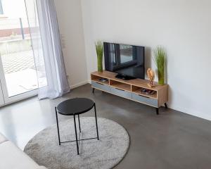 a living room with a black stool and a tv at Ferienwohnung am Erzberg in Fürth