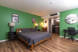 a bedroom with a bed and a green wall at Modern Motel in Colorado Springs