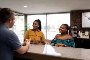 a man and two women standing at a counter at Modern Motel in Colorado Springs
