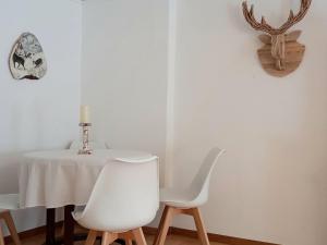 a table and two white chairs in a room at Cozy holiday apartment in the Black Forest in Dachsberg im Schwarzwald