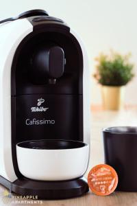 a coffee maker sitting on a table with a cup at Pineapple Apartments Dresden Mitte II - free parking in Dresden +6 photos