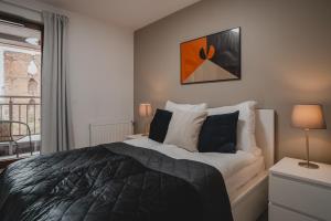 a bedroom with a large bed and a window at TOTU HOME Waterlane Island Apartments in Gdańsk