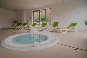 a large room with a hot tub and chairs at TOTU HOME Waterlane Island Apartments in Gdańsk