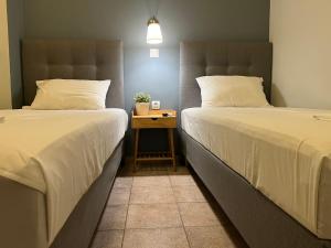 dos camas sentadas una al lado de la otra en una habitación en Maro's Apartments, en Argostoli