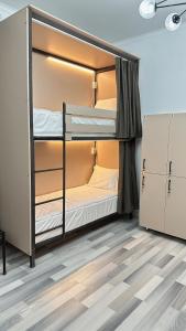 Da! Hostel في بيشكيك: سريرين بطابقين في غرفة مع أرضية خشبية