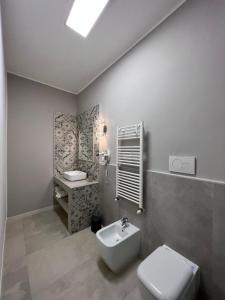 a white bathroom with a toilet and a sink at Stanze d’Autore in Taranto