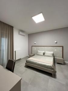 a bedroom with a bed and a table and a chair at Stanze d’Autore in Taranto