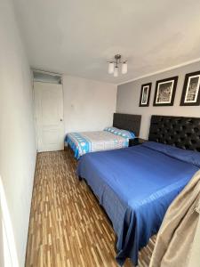a bedroom with two beds with blue sheets at Apartamento Con Estilo A 4 Min Del Aeropuerto-6 Piso! in Lima