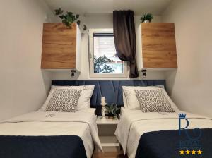 twee bedden in een kleine kamer met een raam bij Royal R mobile homes, kamp Soline, Biograd in Biograd na Moru