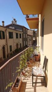 uma varanda com uma cadeira e algumas plantas sobre ela em Appartamento La Valle em Passignano sul Trasimeno