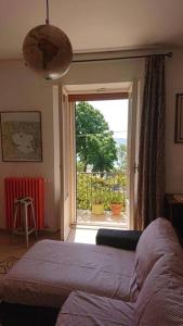 um quarto com uma cama e uma grande janela em Appartamento La Valle em Passignano sul Trasimeno