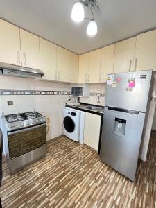 a kitchen with a refrigerator and a stove and a dishwasher at Apartamento Con Estilo A 4 Min Del Aeropuerto-6 Piso! in Lima