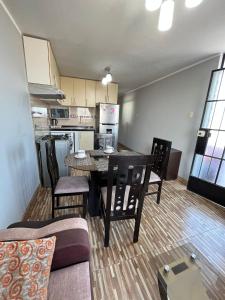 a living room with a table and chairs and a kitchen at Apartamento Con Estilo A 4 Min Del Aeropuerto-6 Piso! in Lima