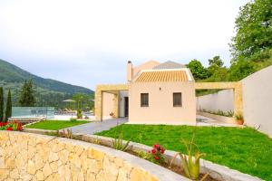 Casa blanca con pared de piedra y patio en Villa Scorpios en Kynopiástai