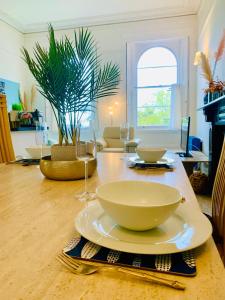 a table with bowls and plates on top of it at **Sunny and Bright, Thatchers Rock One bed beach front apartment*** in Torquay