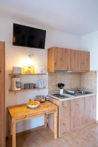 a kitchen with a table with a bowl of fruit on it at Tselios Apartments & Studios in Kiotari