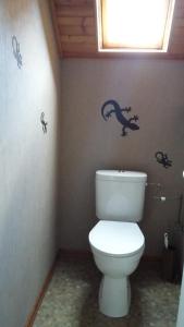 a bathroom with a toilet with dinosaur decals on the wall at Gîte du vigneron in Mittelwihr