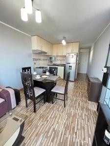 Apartamento Con Estilo A 4 Min Del Aeropuerto-6 Piso! في ليما: مطبخ وغرفة معيشة مع طاولة وكراسي