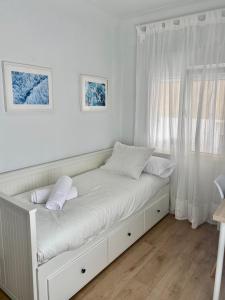 een wit bed in een kamer met een raam bij Pleno centro, cerca de todo con wifi gratis y ascensor in Santander