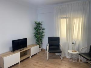 a living room with a television and a chair at Pleno centro, cerca de todo con wifi gratis y ascensor in Santander