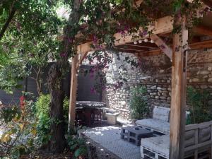 a garden with a wooden pergola and a bench at Charmante maison de ville avec jardin in Perpignan