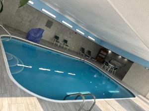 una piscina in una stanza d'ospedale con sedie di Country Inn & Suites by Radisson, Grand Rapids Airport, MI a Grand Rapids