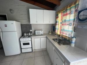 a small kitchen with a white refrigerator and a sink at Andes cerros departamento en mendoza ciudad in El Challao