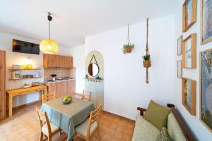 a living room with a table and a kitchen at Tselios Apartments & Studios in Kiotari