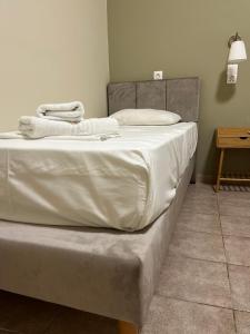 una cama con sábanas blancas en una habitación en Maro's Apartments, en Argostoli